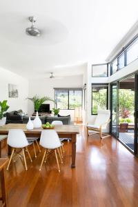 a living room with a wooden table and white chairs at Lily Pad at Byron Bay in Byron Bay