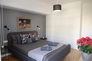 a bedroom with a bed and a vase with flowers at Boutique Apartment in Chalandri in Athens