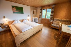 um quarto com uma cama de madeira e uma mesa e uma mesa sidx sidx em Sonnmatt Bergpension & Gesundheitszentrum em Ebnat