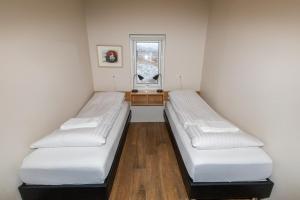 two beds in a room with a window at Hrimland Cottages in Akureyri