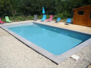 a swimming pool with chairs and a group at Studio/Gîte Les Papillons in Lablachère