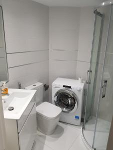 a bathroom with a toilet and a washing machine at Style Apartment with Ocean view in Playa de las Americas