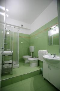 a green bathroom with a toilet and a sink at Arcobaleno Guest House Pellaro in Pellaro +24 photos