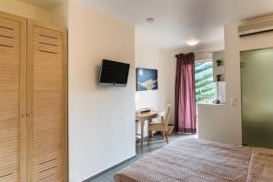 a bedroom with a bed and a desk and a tv on a wall at Mirage Studios in Malia