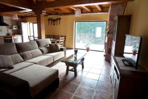 ein Wohnzimmer mit einem Sofa und einem Tisch in der Unterkunft Alameda I con CHIMENEA Salón y BARBACOA patio in Curiel de Duero