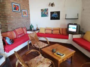 sala de estar con sofás y TV en Casa Lago Azul en Córdoba