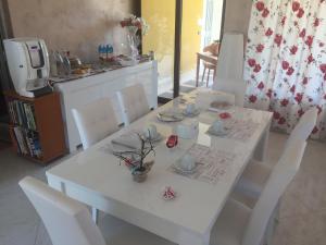 a white table with white chairs and flowers on it at Rudy Arenaile in Arenella