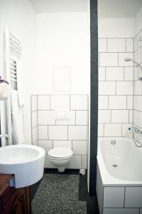 a bathroom with a sink and a toilet and a tub at 3 Bedroom Apartment (ACELI) in Berlin