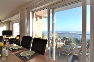 a dining room with a table and a large glass window at Suncliff in Ventnor