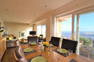 a dining room with a table with chairs and a large window at Suncliff in Ventnor