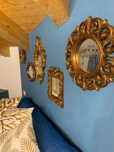 基奧賈的住宿－La Bella Vita - La Casetta，一间蓝色墙壁上配有金色镜子的卧室