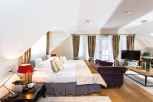 a hotel room with two beds and a television at Lesar Hotel Angel - Member of Hip Hotels in Ljubljana