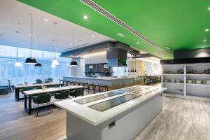 un ristorante con tavoli e soffitto verde di Studio M Arabian Plaza Hotel & Hotel Apartments a Dubai