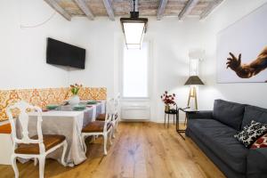 - un salon avec une table et un canapé dans l'établissement GetThekey San Vitale Apartment, à Bologne