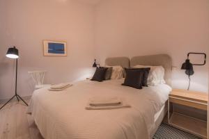a bedroom with a large white bed with black pillows at LovelyStay - Charming 3 Bedroom Wonder Downtown in Lisbon