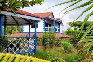 una casa azul con techo rojo en Aqua Arina Holiday Farm House, en Murud