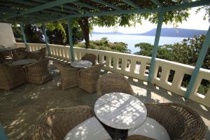 un patio con mesas y sillas y el océano en Casa Kalypso, en Steni Vala Alonissos