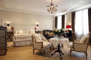 卢布尔雅那Lesar Hotel Angel - Member of Hip Hotels的一间卧室，里面有一张床、一张桌子和几把椅子。