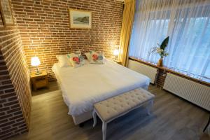 ein Schlafzimmer mit einem großen Bett und einer Ziegelwand in der Unterkunft Buitengoed de Panoven in Zevenaar