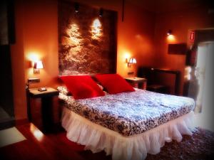 1 dormitorio con 1 cama con almohadas rojas en Almazara de San Pedro en Eljas