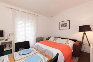 カンヌにあるCute 1 bedroom flat - Croisette areaのベッドルーム1室(ベッド1台、テーブル、プレート付)