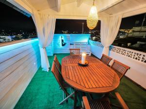 a wooden table and chairs on a balcony at night at Casa Carmen Altea with Terrace in Altea