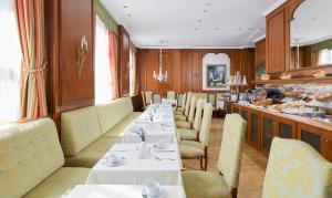 a restaurant with long tables and chairs and a counter at Living Hotel Berlin Mitte in Berlin