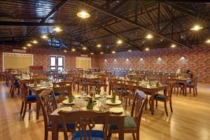 Un comedor con mesas y sillas en un edificio. en Gir Lion Safari Camp by Trulyy, Sasan Gir, en Sodaori