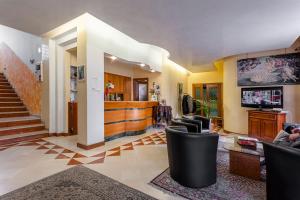 a living room with chairs and a tv and stairs at Hotel Sporting in Casarsa della Delizia