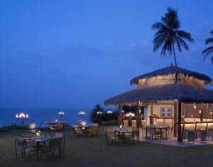 a restaurant with tables and chairs in front of a building at Taj Bentota Resort & Spa in Bentota