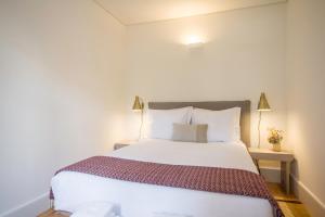 ポルトにあるOporto Sweet Home IVのベッドルーム(大きな白いベッド1台、ランプ2つ付)