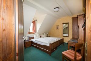 a bedroom with a bed and a table and a chair at Burgschänke & Herberge Goldener Löwe in Bad Düben