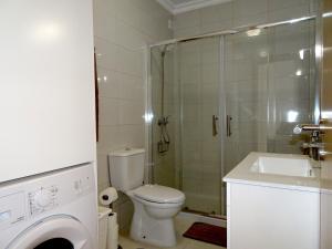 a bathroom with a shower and a toilet and a sink at Copacabana by Check-in Portugal in Vilamoura