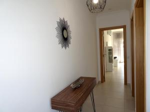 a hallway with a table and a mirror on the wall at Copacabana by Check-in Portugal in Vilamoura