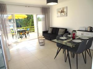 a living room with a table and a couch at Copacabana by Check-in Portugal in Vilamoura