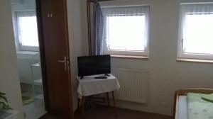 a television sitting on a table in a room with windows at Guest House Honzik in Horní Maršov