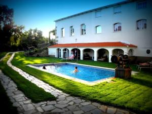 a person in a swimming pool in front of a building at Almazara de San Pedro in Eljas