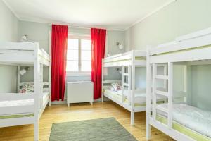 エンシェーピングにあるFirst Camp Bredsand-Enköpingのベッドルーム1室(白い二段ベッド、赤いカーテン付)