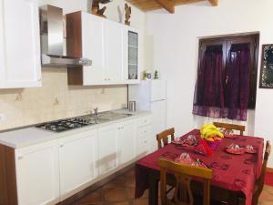 uma cozinha com armários brancos e uma mesa com uma toalha de mesa vermelha em Aquila Di Mare em Fiumicino