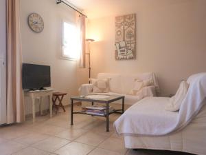 ein Wohnzimmer mit einem Sofa und einem TV in der Unterkunft GASLIND - Golfe de St-Tropez - Mazet dans domaine privé avec piscine in Gassin