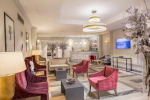 een lobby met roze stoelen en een woonkamer bij Hotel Della Conciliazione in Rome