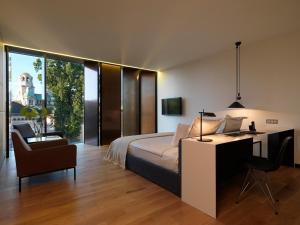 a bedroom with a bed and a desk and a chair at Sense Hotel Sofia, a Member of Design Hotels in Sofia