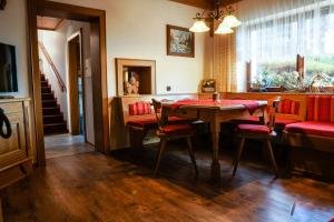 comedor con mesa, sillas y ventana en Pension Sonnleit'n en Kirchdorf in Tirol