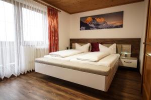 a bedroom with a large white bed in a room at Pension Sonnleit'n in Kirchdorf in Tirol