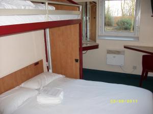 1 dormitorio con 2 literas y ventana en Metro Inns Falkirk, en Falkirk