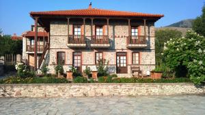 a large stone building with a balcony in front of it at Varnous Hotel in Agios Germanos