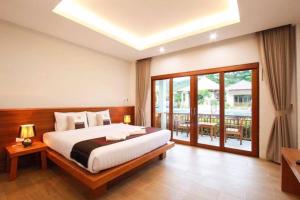 1 dormitorio con 1 cama grande y balcón en Verona Lanta Resort en Ko Lanta