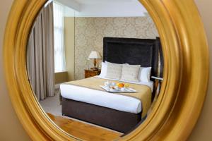 a bedroom with a mirror and a bed at The Lake Hotel in Killarney