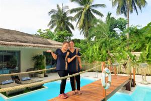 two women standing on a bridge by a pool at AMAYA Resort in Lamai