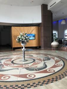 eine Lobby mit einer Blumenvase auf dem Boden in der Unterkunft Holiday apartments in Haifa